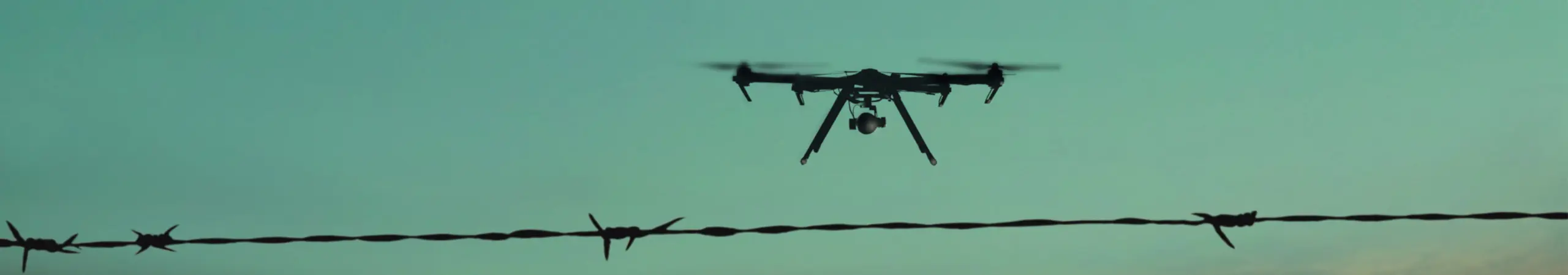 drone flying over a security fence